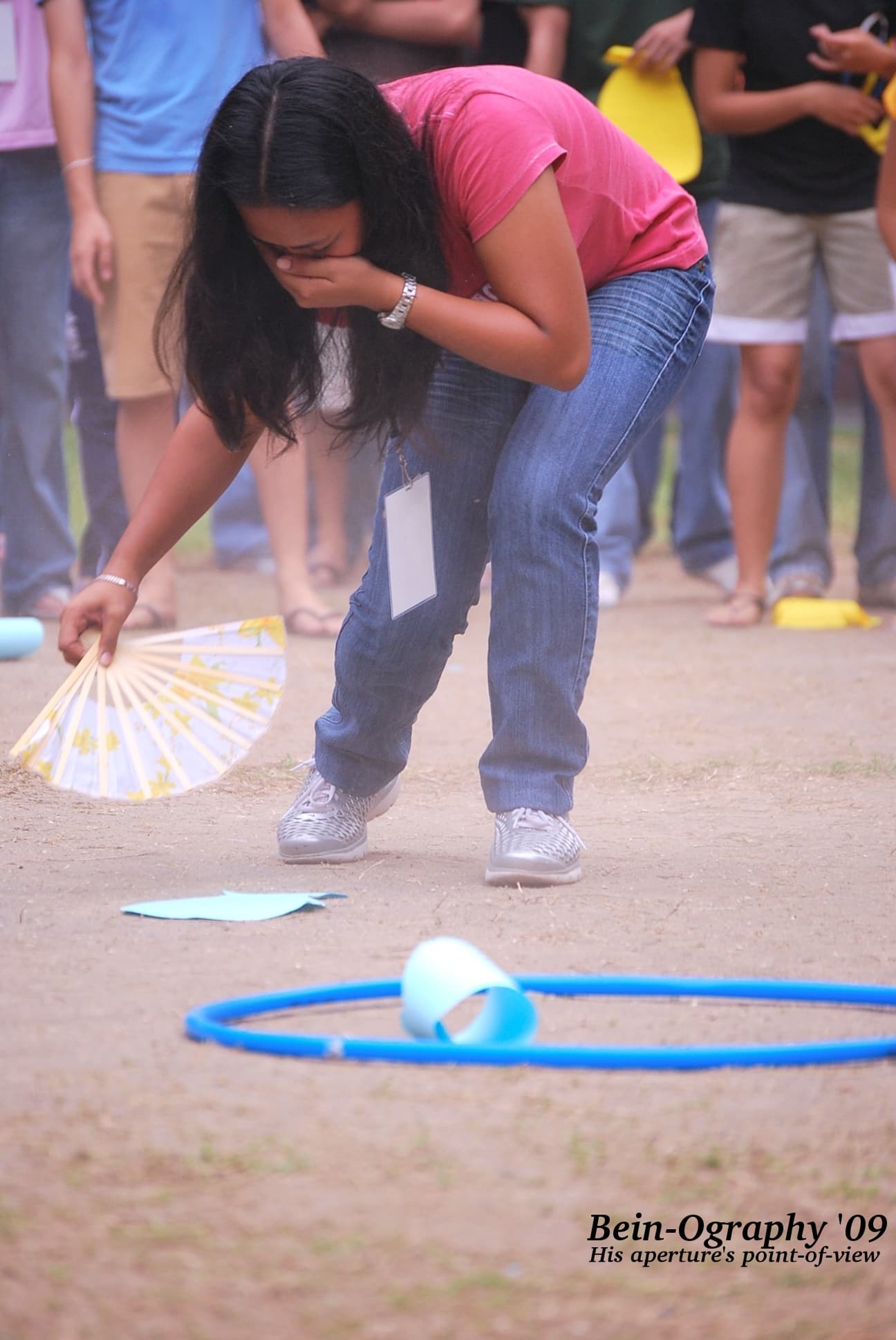 A participant covering her nose while fanning a paper on the ground